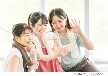 スポーツジムのヨガ教室で休憩をしながらスマホで写真を撮る女性達 スポーツジムのヨガ教室で休憩をしながらスマホで写真を撮る女性達 117555148