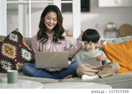 asian mother and son using laptop and digital tablet at home asian mother and son using laptop and digital tablet at home 117555399