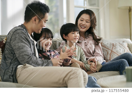 young asian family with two children watching tv together at home young asian family with two children watching tv together at home 117555480
