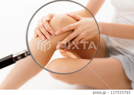 女性の膝をルーペで拡大している。 女性の膝をルーペで拡大している。 117555785