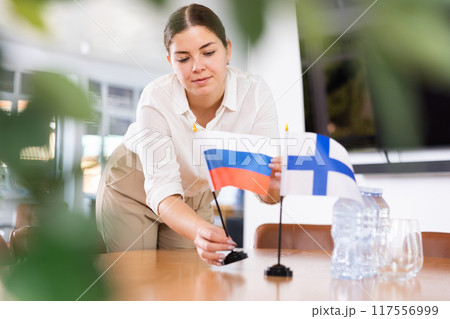 female assistant prepares conference room for diplomats of Finland and Russia 117556999