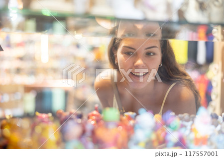 Young happy girl looking at souvenirs in gift shop window 117557001