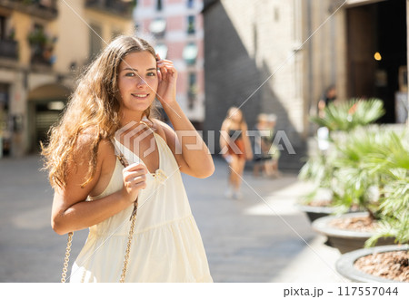 In pedestrian zone of historic European city walking female tourist girl In pedestrian zone of historic European city walking female tourist girl 117557044