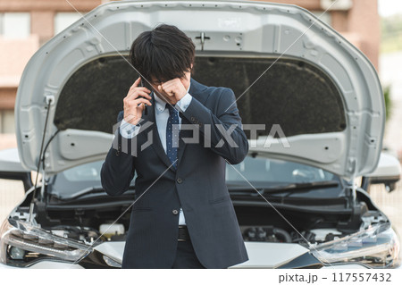 自動車の前でスマホで電話する若いアジア人男性(ロードサービス・トラブル・レスキュー・困る) 自動車の前でスマホで電話する若いアジア人男性(ロードサービス・トラブル・レスキュー・困る) 117557432