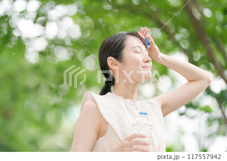 公園を散歩して汗を拭く女性 公園を散歩して汗を拭く女性 117557942