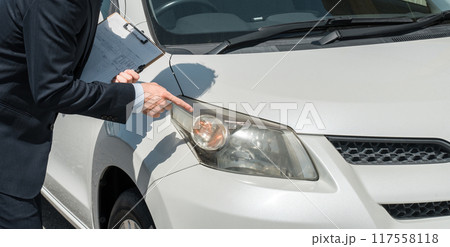 チェック表を使って車の査定・見積もりをするセールスマン・査定士の手元 117558118