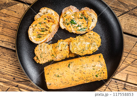 Butter with flavoring additives, sandwich butter with fresh herbs, sweet peppers, lemon, onion, garlic. Wooden background. Top view 117558853