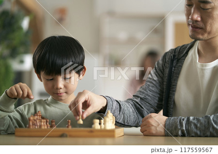 young asian father playing chess with son at home young asian father playing chess with son at home 117559567