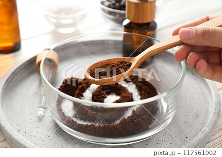 Coffee scrub for the body, in a plate with care products, on a white background. Coffee scrub for the body, in a plate with care products, on a white background. 117561002