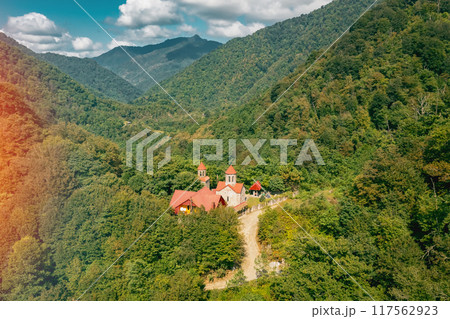 Aerial view of a serene mountain male monastery in a lush forest, evoking tranquility and calmness 117562923