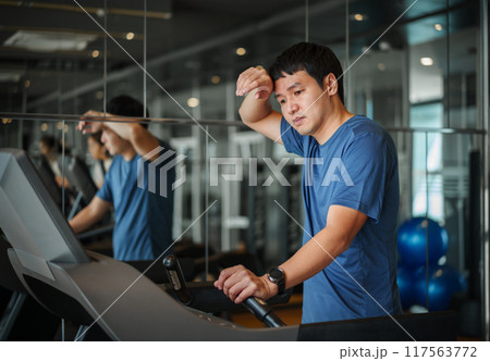 man feeling tired after running on treadmill at fitness gym exercise man feeling tired after running on treadmill at fitness gym exercise 117563772