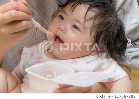 【離乳食を食べる髪を結んだ赤ちゃん】 【離乳食を食べる髪を結んだ赤ちゃん】 117567198
