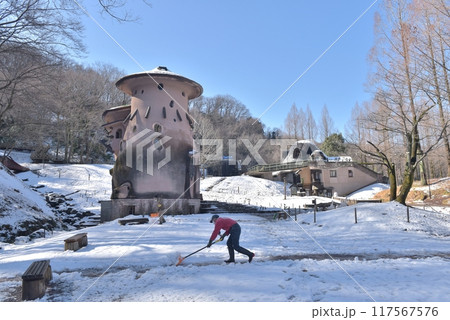 雪が降ったあけぼの子どもの森公園、青空の下、きのこの家の前で除雪作業を行う 117567576