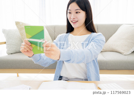 通帳を見て喜ぶ女性 通帳を見て喜ぶ女性 117569023