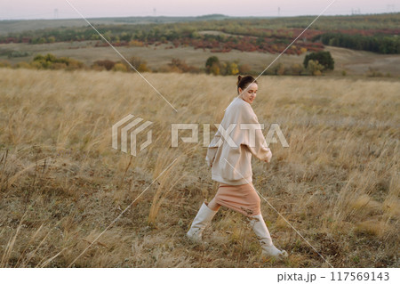 Beautiful woman walk in the field sunny day Beautiful woman walk in the field sunny day 117569143