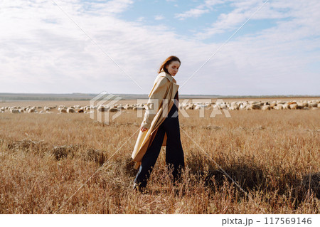 Young woman in stylish clothes posing in autumn field. Nature, fashion, lifestyle. Travel. Young woman in stylish clothes posing in autumn field. Nature, fashion, lifestyle. Travel. 117569146