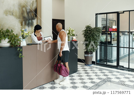 Man Consulting About Sport Program At Reception Man Consulting About Sport Program At Reception 117569771