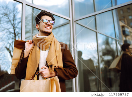 Stylish man with paper packages after shopping. Sale, consumerist, lifestyle concept. 117569787