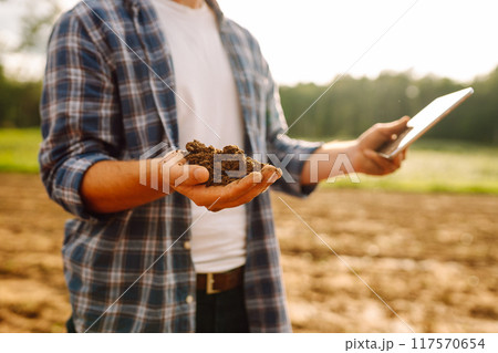Gardening or ecology concept. Farmer's hands collects soil and checks its health before growing crop 117570654