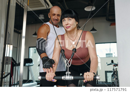Woman Training With Personal Trainer In Gym 117571791