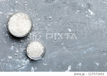 A wooden bowl of salt crystals on a wooden background. Salt in rustic bowls, top view with copy space A wooden bowl of salt crystals on a wooden background. Salt in rustic bowls, top view with copy space 117571852