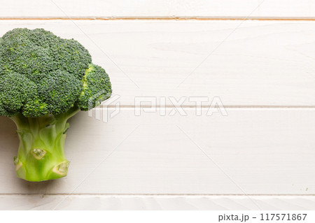Top view fresh green broccoli vegetable on Colored background. Broccoli cabbage head Healthy or vegetarian food concept. Flat lay. Copy space 117571867