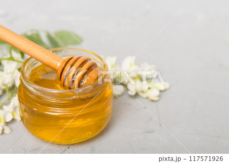 robinia honey bollte with acacia blossoms on colored table 117571926