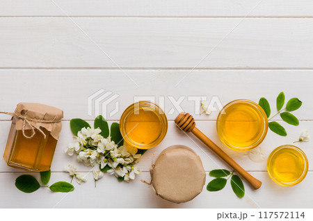 honey jar with acacia flowers and leaves. fresh honey top view flat lay honey jar with acacia flowers and leaves. fresh honey top view flat lay 117572114
