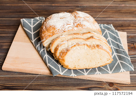 Assortment of freshly sliced baked bread with napkin on rustic table top view. Healthy unleavened bread. French bread slice 117572194