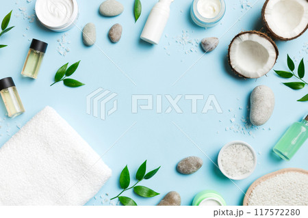 Coconut with jars of coconut oil and cosmetic cream on colored background. Top view. Free space for your text. Natural spa coconut cosmetics and organic treatment concept Coconut Spa composition Coconut with jars of coconut oil and cosmetic cream on colored background. Top view. Free space for your text. Natural spa coconut cosmetics and organic treatment concept Coconut Spa composition 117572280
