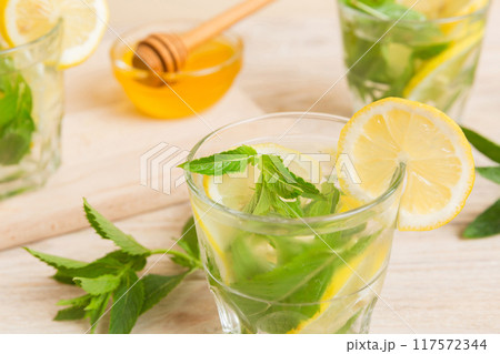 Mojito cocktail. Refreshing mojito cocktail with lime, lemon and mint in a tall glass with a stick 117572344