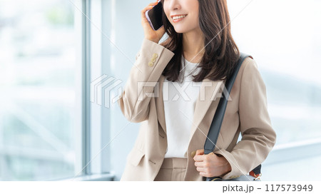 スマホで話す笑顔の日本人ビジネスウーマン スマホで話す笑顔の日本人ビジネスウーマン 117573949