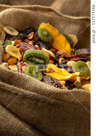 Dried tropical fruits and nuts in burlap bag. 117574166