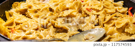 Delicious cooked Italian farfalle pasta butterfly or bow with cheese sauce. Delicious cooked Italian farfalle pasta butterfly or bow with cheese sauce. 117574593