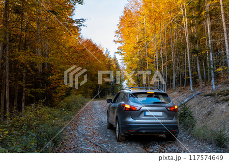SUV on a Scenic Autumn Gravel Road SUV on a Scenic Autumn Gravel Road 117574649