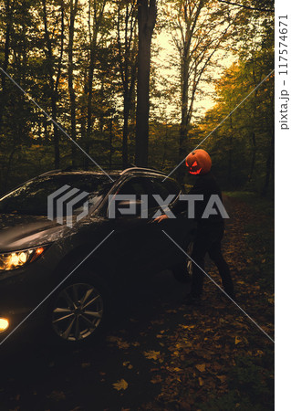halloween concept man with pumpkin head in suv car halloween concept man with pumpkin head in suv car 117574671
