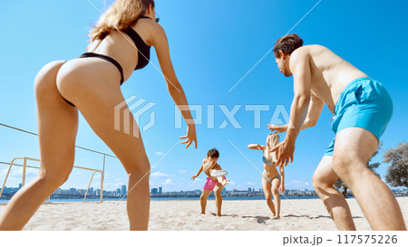 Active summer vacation. Young people, friends playing frisbee in beach by the river, enjoying dynamic game and good company 117575226