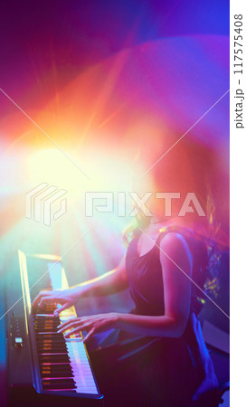Surrounded by spectrum of radiant colors, vibrant stage lights, pianist loses herself in music. Instrumental performance. Surrounded by spectrum of radiant colors, vibrant stage lights, pianist loses herself in music. Instrumental performance. 117575408