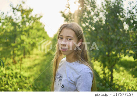 a portrait of a teenage girl with long blond hair in a sunlit garden a portrait of a teenage girl with long blond hair in a sunlit garden 117577157