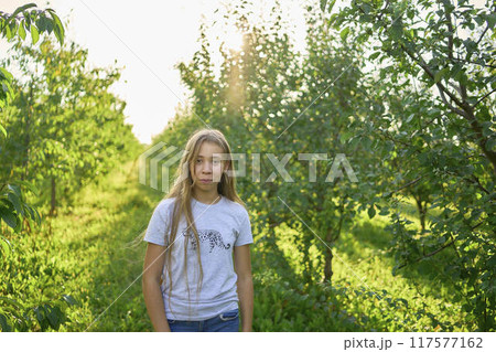 a portrait of a teenage girl with long blond hair in a sunlit garden a portrait of a teenage girl with long blond hair in a sunlit garden 117577162