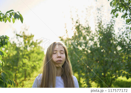 a portrait of a teenage girl with long blond hair in a sunlit garden a portrait of a teenage girl with long blond hair in a sunlit garden 117577172