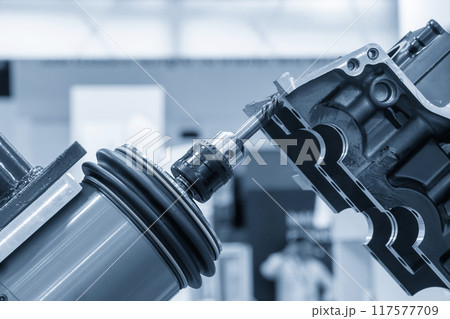 Closeup scene the milling spindle attached on the robotic arm finish cut the aluminum gear case. 117577709