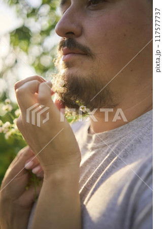 the wife weaves flowers into her husband's beard the wife weaves flowers into her husband's beard 117577737
