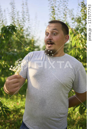 a man laughs at the flowers in his beard that his wife has woven into him 117577743