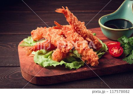Fried shrimp, peeled in tempura, soy sauce, close-up, on a wooden board, 117578082