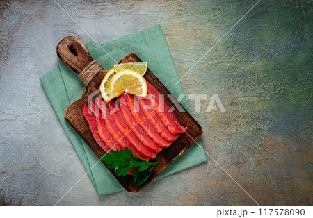 chum salmon, cold smoked, sliced, on a cutting board, with lemon and parsley, top view, close-up, no people, chum salmon, cold smoked, sliced, on a cutting board, with lemon and parsley, top view, close-up, no people, 117578090