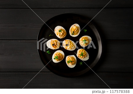 Boiled eggs stuffed with yolk with mayonnaise, on a black plate, selective focus, blurry, close-up, no people, Boiled eggs stuffed with yolk with mayonnaise, on a black plate, selective focus, blurry, close-up, no people, 117578388