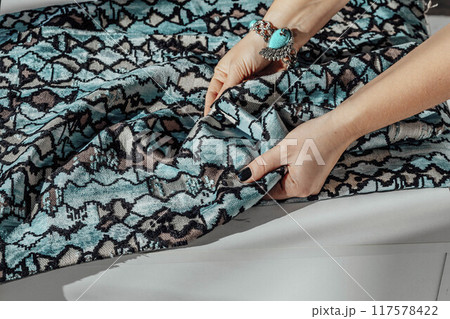 hand interacting with a richly textured fabric, symbolizing the craftsmanship and creativity behind every piece of fashion hand interacting with a richly textured fabric, symbolizing the craftsmanship and creativity behind every piece of fashion 117578422