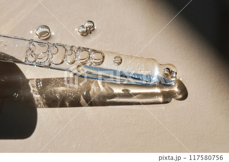Pipette with serum on a beige background. Pipette with serum on a beige background. 117580756