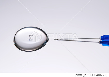 A drop of medicine flowing from a syringe with a needle. A drop of medicine flowing from a syringe with a needle. 117580779
